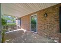 The brick-paved covered porch offers a shady spot by the front door with ample room for seating at 8222 Henry Harris Rd, Fort Mill, SC 29707