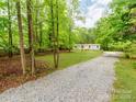 Long gravel driveway leading to a cozy home nestled among lush, mature trees and greenery at 850 Deep Hollow Ct, Clover, SC 29710