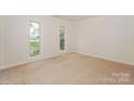 Neutral bedroom with large windows offering natural light and plush carpet flooring at 8709 Stratton Farm Rd, Huntersville, NC 28078