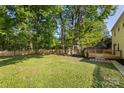Spacious backyard featuring a lush lawn, mature trees, and a newly installed wooden fence at 910 Lightwood Dr, Matthews, NC 28105