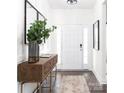 Bright entryway featuring white walls, a dark wood floor, console table with decor, and front door with sidelights at 105 Nighthawk Trl # 20, Mooresville, NC 28115