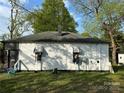 The back of the home has white wood paneling, a small set of awning windows, and a blue patio chair at 1210 Congress St, Gastonia, NC 28054