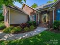 Close-up of the brick facade and front entrance, with mature landscaping at 1257 Mill Race Ln, Matthews, NC 28104
