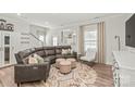 Stylish living room with a large sectional sofa, plush ottomans, and bright natural light at 1316 Colgher St, Mint Hill, NC 28227