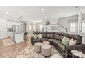 Open-concept living space with a modern sofa, kitchen island, and staircase at 1316 Colgher St, Mint Hill, NC 28227