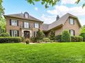 Elegant brick home with a manicured lawn and dark shutters at 14650 Trading Path Way, Charlotte, NC 28277