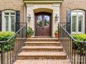 Elegant entryway with brick steps, wrought iron railings, and double wooden doors at 14650 Trading Path Way, Charlotte, NC 28277