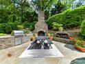 Outdoor kitchen and dining area with stone fireplace and professional grade stainless steel grill at 14650 Trading Path Way, Charlotte, NC 28277