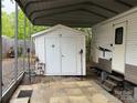 White storage shed next to a white RV under a metal carport cover at 148 Sunshine Trl # A165, Mount Gilead, NC 27306