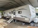 White RV with a metal carport cover, gravel area and concrete blocks for support at 148 Sunshine Trl # A165, Mount Gilead, NC 27306
