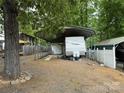 White RV with a metal carport cover surrounded by gravel and fencing at 148 Sunshine Trl # A165, Mount Gilead, NC 27306
