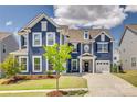 Charming two-story blue home with lush green lawn and mature landscaping at 14925 Baldridge Dr, Huntersville, NC 28078