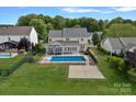 Aerial view of a backyard with a pool, patio area, fenced yard, and mature trees at 156 Pecan Hills Dr, Mooresville, NC 28115