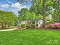 Landscaped home with a sprawling lawn and mature trees creates an inviting curb appeal at 1733 Piccadilly Dr, Charlotte, NC 28211