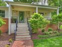 Inviting front porch with stone accents, brick walkway, and manicured landscaping at 1733 Piccadilly Dr, Charlotte, NC 28211
