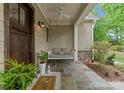 Inviting covered front porch featuring a porch swing, stone flooring, and tasteful decor at 20614 Pointe Regatta Dr, Cornelius, NC 28031