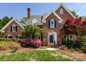 Charming brick home with manicured lawn, colorful azaleas and mature trees at 216 Liriope Ct, Matthews, NC 28105