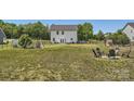 Large backyard features a firepit seating area, swing set, shed and white fencing at 2206 Mills Harris Rd, Wingate, NC 28174