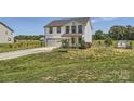 Two-story home with a garage and inviting front porch, framed by a green lawn at 2206 Mills Harris Rd, Wingate, NC 28174