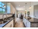 Modern kitchen featuring white cabinets, granite countertops, stainless steel appliances, and hardwood flooring at 2206 Mills Harris Rd, Wingate, NC 28174