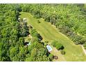 Expansive aerial view showcasing the property, including a long lawn, pool, and wooded area at 237 Fea Ln, Iron Station, NC 28080