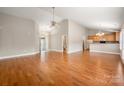 Spacious living area featuring hardwood floors, vaulted ceiling, and seamless flow to the kitchen at 2412 Laura Dr, Charlotte, NC 28212