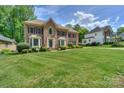 Beautiful brick home with a well-manicured lawn and mature landscaping at 3119 Castlemaine Dr, Charlotte, NC 28269