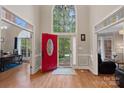 Bright foyer featuring a grand, high window over a red front door and hardwood floors at 3124 Lakewood Edge Dr, Charlotte, NC 28269