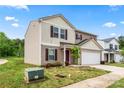 Beige two-story home with a white garage door and a small tree in the front yard under a blue sky at 355 Jared Steel Ln, Salisbury, NC 28146