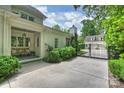 View of the property showing outdoor seating, a gated entrance, and lush, mature landscaping at 3950 Abingdon Rd, Charlotte, NC 28211