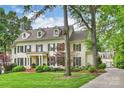 Elegant home with a side view revealing the garage and driveway, framed by lush landscaping at 3950 Abingdon Rd, Charlotte, NC 28211