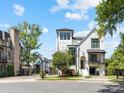 White home with black trim on a corner lot showcasing professional landscaping and mature trees at 443 Beaumont Ave, Charlotte, NC 28204