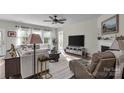 Bright living room featuring a comfortable sofa, large windows, and a cozy fireplace with a mounted television at 5104 Samoa Ridge Dr, Lancaster, SC 29720
