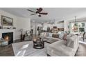 Spacious open-concept living room with a fireplace, ceiling fan, and seamless flow into a modern kitchen at 5104 Samoa Ridge Dr, Lancaster, SC 29720
