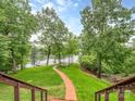 Beautiful backyard with a red brick pathway and lake access and views, surrounded by mature trees at 5951 Johnson Rd, Clover, SC 29710