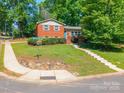 Corner lot featuring a well-maintained home, retaining wall, and healthy, green lawn at 6338 Rosecrest Dr, Charlotte, NC 28210