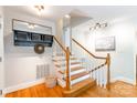 Inviting foyer with hardwood floors, coat rack and staircase at 6338 Rosecrest Dr, Charlotte, NC 28210