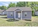 Charming home with a covered front porch, gray siding, a new roof, and green grass at 703 S Main St, Landis, NC 28088
