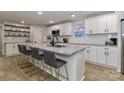 Bright kitchen features white cabinets, granite countertops, stainless appliances, island with seating, and floating shelves at 703 S Main St, Landis, NC 28088