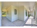 Spacious covered porch featuring classic white wooden paneling and stylish lighting fixtures at 7768 Lynwood Ln, Sherrills Ford, NC 28673