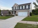 Beautiful two-story home with brick and siding, a well-manicured lawn, and an attached two-car garage at 8901 Powder Works Dr, Huntersville, NC 28078