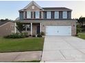 Beautiful two-story home with brick and siding, a well-manicured lawn, and an attached two-car garage at 8901 Powder Works Dr, Huntersville, NC 28078
