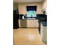 The kitchen has a window over the sink, white cabinets and black appliances at 918 Carmel Dr, Gastonia, NC 28056