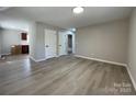 Open living room featuring sleek floors, neutral walls, recessed lighting, and access to the kitchen and bathroom at 113 Burke Cir, Mooresville, NC 28115