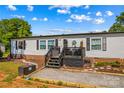 Welcoming front porch with black railings and decor, complemented by a beautifully landscaped front yard at 114 Doubletree Dr, Statesville, NC 28677
