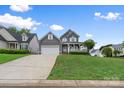Charming two-story home with welcoming front porch, neutral siding, a two-car garage and a lush, sloped front yard at 1358 Colwick Ln, Rock Hill, SC 29732