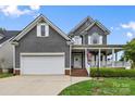 Charming two-story home boasts a welcoming front porch, neutral siding, a two-car garage, and well-maintained landscaping at 1358 Colwick Ln, Rock Hill, SC 29732