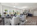 Open-concept living area with hardwood floors, stylish furniture, and a modern kitchen in the background at 143 Stonewater Dr # 13P, Red Cross, NC 28129