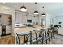 Bright kitchen with a large island, modern pendant lights, and gray cabinets, seamlessly flowing into the living space at 15813 Capps Rd, Charlotte, NC 28278