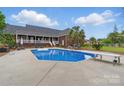 Inviting backyard pool area with diving board, surrounded by lush greenery and palm trees at 172 Fairway Cir, Rock Hill, SC 29730